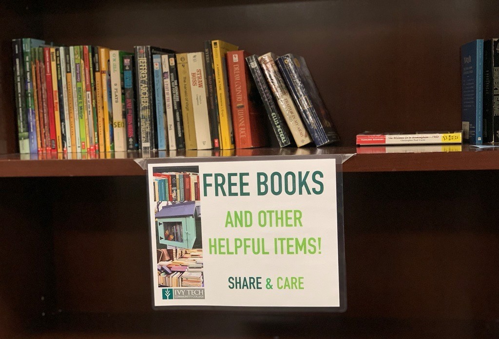 Professor stocks bookshelf with free books for Ivy Tech Indianapolis students